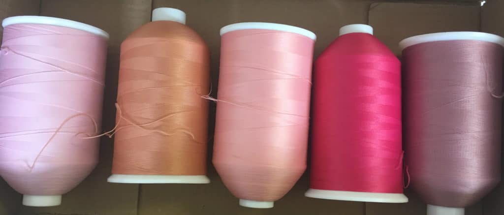 pink sewing machine thread reels