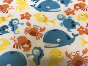white dress fabric with childs whales and crabs design
